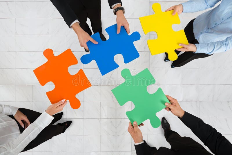 Businesspeople Holding Puzzle Pieces