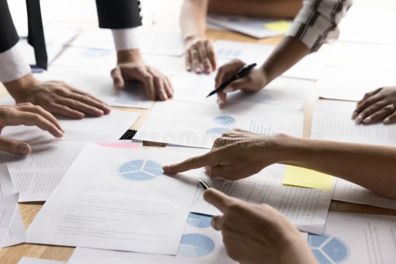 Businesspeople review graphs and pie charts, focused on data analysis stock photo