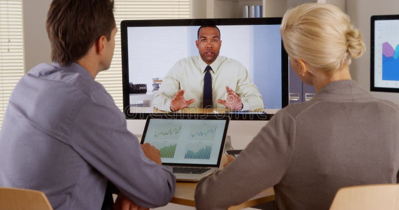 Businessteam die aan manager in een videoconferentie luisteren stock afbeelding Businessteam die aan manager in een videoconferentie luisteren stock afbeelding