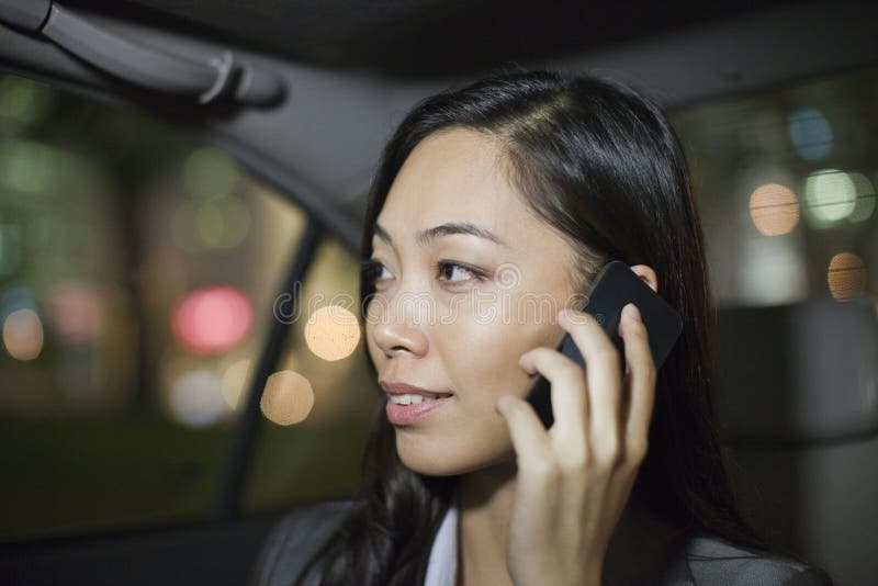 Businesswoman With Cell Phone In Car Back