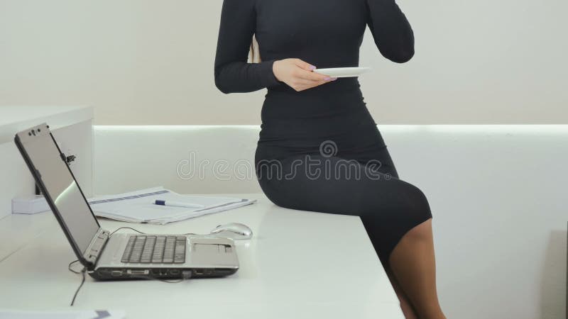 Businesswoman drinks coffee at the office