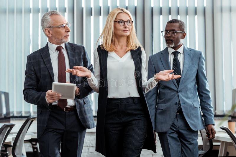 Businesswoman gesturing near handsome multicultural businessman stock photography