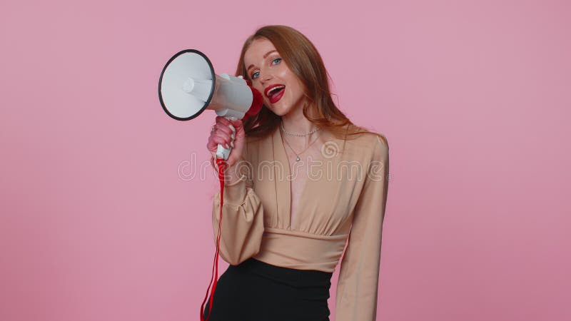 Smiling happy businesswoman girl talking with megaphone, proclaiming news, loudly announcing sale advertisement, warning using loudspeaker to shout speech. Young adult woman on pink studio background