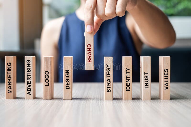 Businesswoman hand placing or pulling wooden Dominoes with BRAND text. and Marketing, Advertising, Logo, Design, Strategy