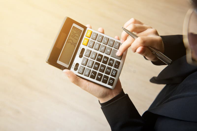 Businesswoman hand pressing calculator royalty free stock image