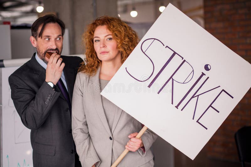 Businesswoman holding big poster with word strike. stock image Businesswoman holding big poster with word strike. stock image