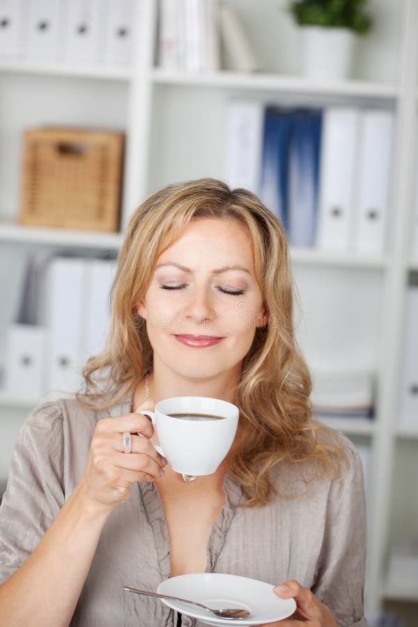 Businesswoman Holding Coffee Cup In Office stock images