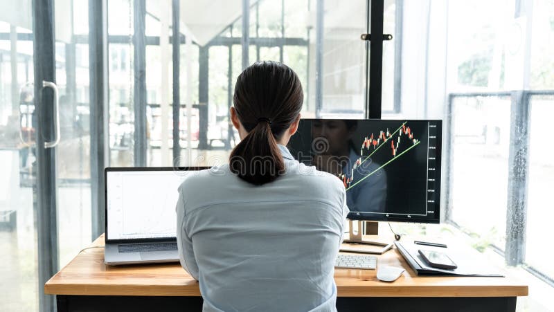 Businesswoman investor having planning and analyzing graph data with display screen the data presented and deal on a stock stock images