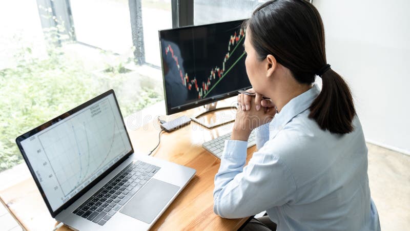 Businesswoman investor having planning and analyzing graph data with display screen the data presented and deal on a stock royalty free stock image