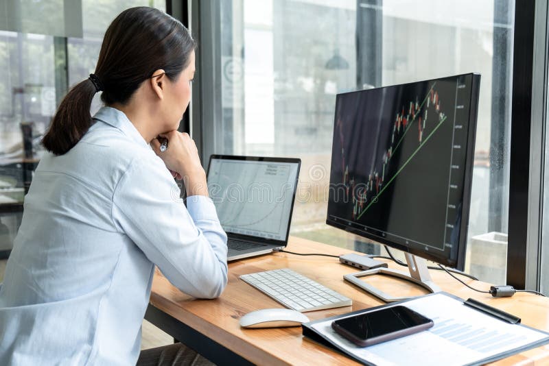 Businesswoman investor having planning a new project and analyzing graph data with display screen the data presented and deal on a stock photo