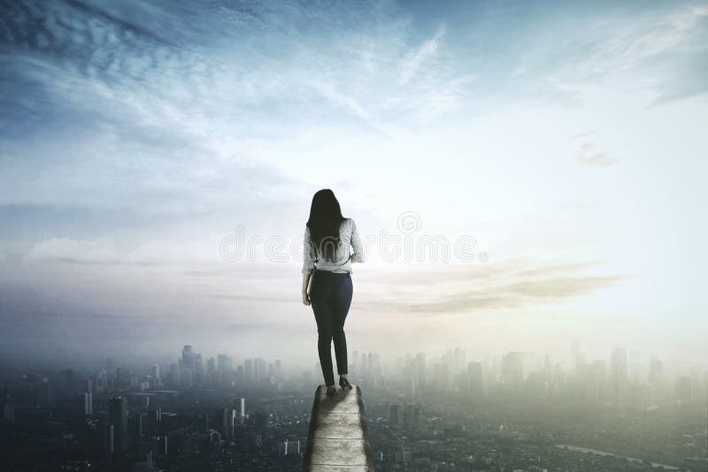 Businesswoman looking at the city from rooftop