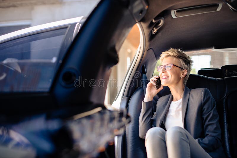 Businesswoman making phone call in limo