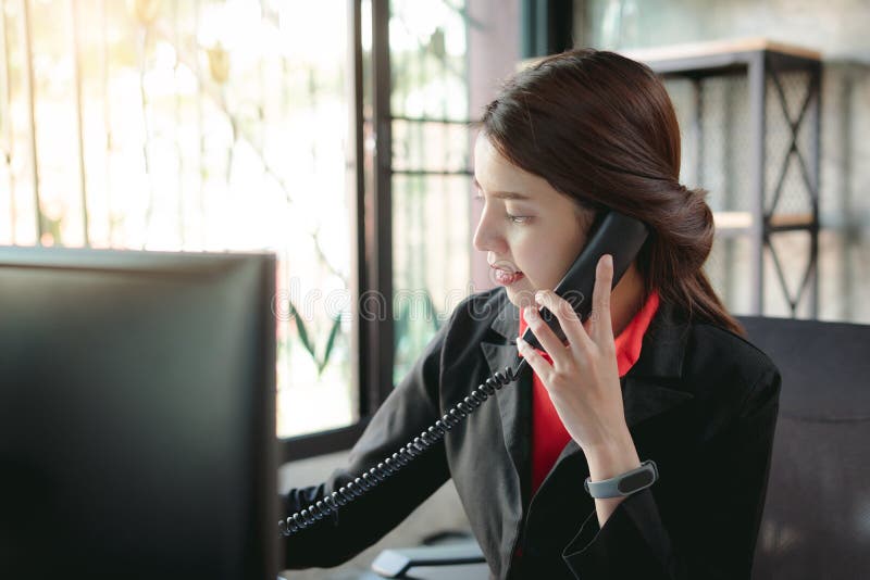 Businesswoman making a phone call.Talking on Landline phone.Concept for communication, contact us and customer service support. Corporate, black.