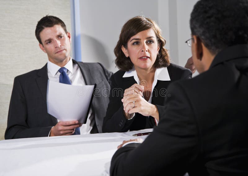 Diverse business people conversing and negotiating, focus on businesswoman, 40s. Negotiating table stock images, royalty-free photos and pictures
