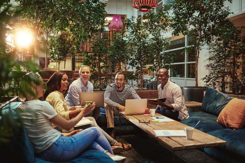 Businesswoman showing smiling diverse colleagues something on he