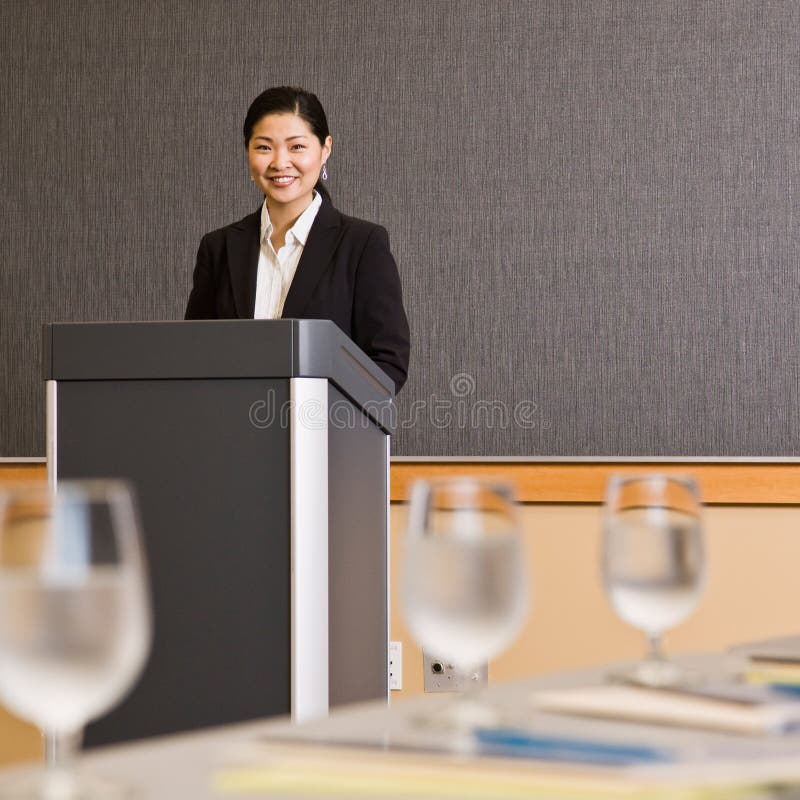 Businesswoman standing behind podium