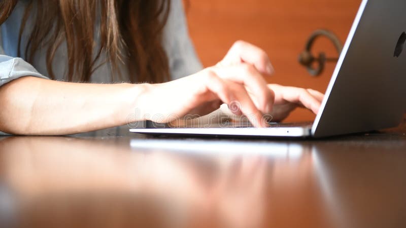 Businesswoman typing on a laptop keyboard while working on a project in her office stock footage