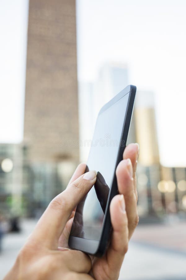 Businesswoman using her mobile phone in front of Building