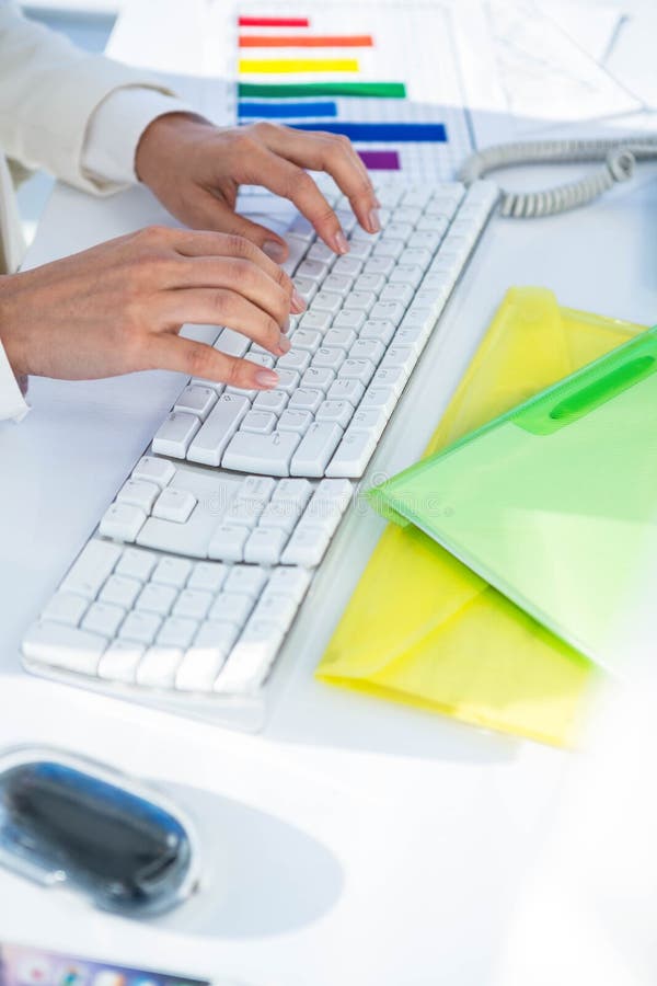 Businesswoman using her pc with documents. At the desk in work stock photo