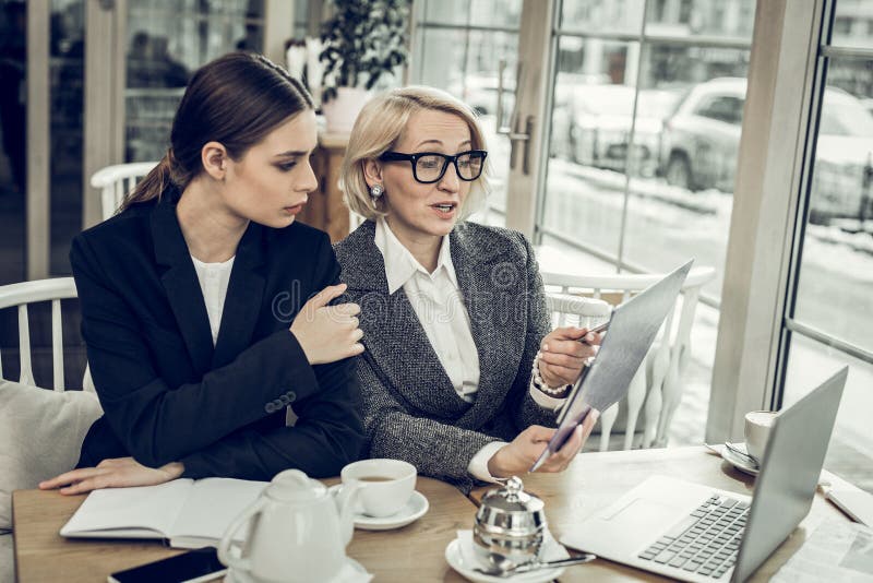 Businesswoman wearing glasses speaking with her young employee royalty free stock photography Businesswoman wearing glasses speaking with her young employee royalty free stock photography