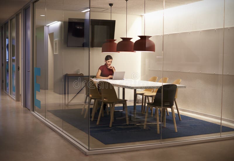 Businesswoman working alone in cubicle at corporate business