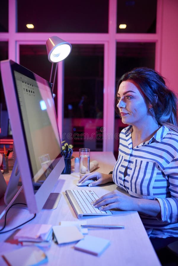 Businesswoman working on computer till night royalty free stock image