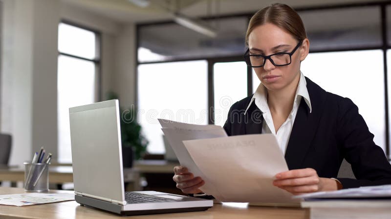 Businesswoman working with papers, checking annual financial report in office stock photos Businesswoman working with papers, checking annual financial report in office stock photos