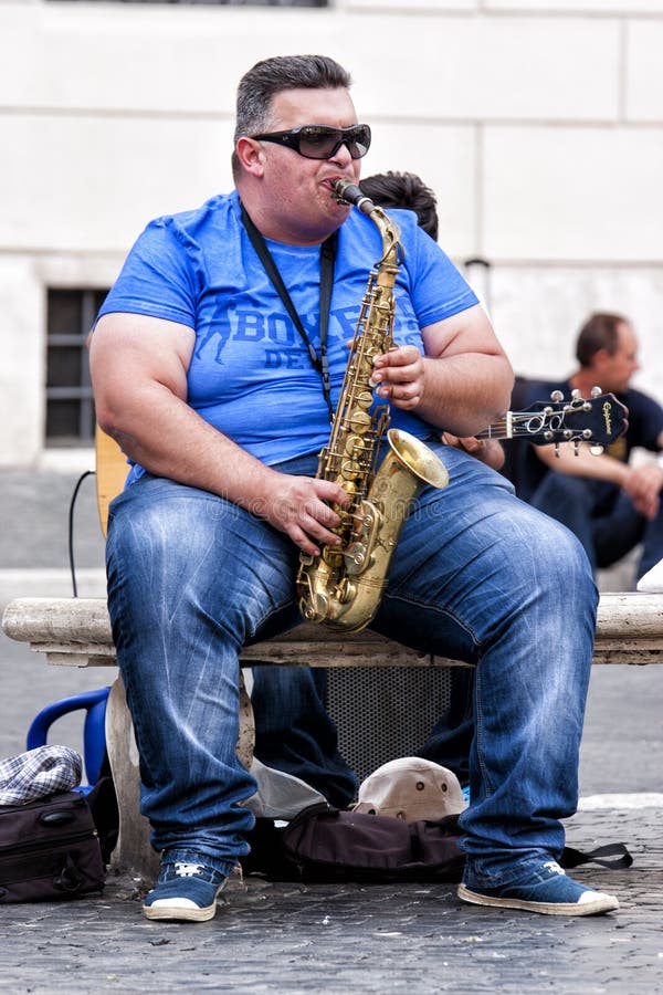 busker-gordo-que-juega-el-saxof%C3%B3n-asentado-en-un-banco-45116351.jpg