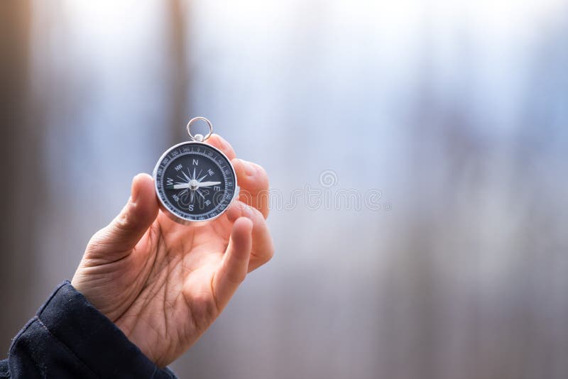 Man on an adventure is holding a compass in his hand for finding is route travel concept target symbol instrument conceptual direction navigation explore marketing landscape outdoors summer expedition business vacation object research forward hiking survival map outside journey holiday green copy text space guidance cracked aging autumn lifestyle seo engine orientation device trip topography tourism sunlight path nobody needle. Man on an adventure is holding a compass in his hand for finding is route travel concept target symbol instrument conceptual direction navigation explore marketing landscape outdoors summer expedition business vacation object research forward hiking survival map outside journey holiday green copy text space guidance cracked aging autumn lifestyle seo engine orientation device trip topography tourism sunlight path nobody needle
