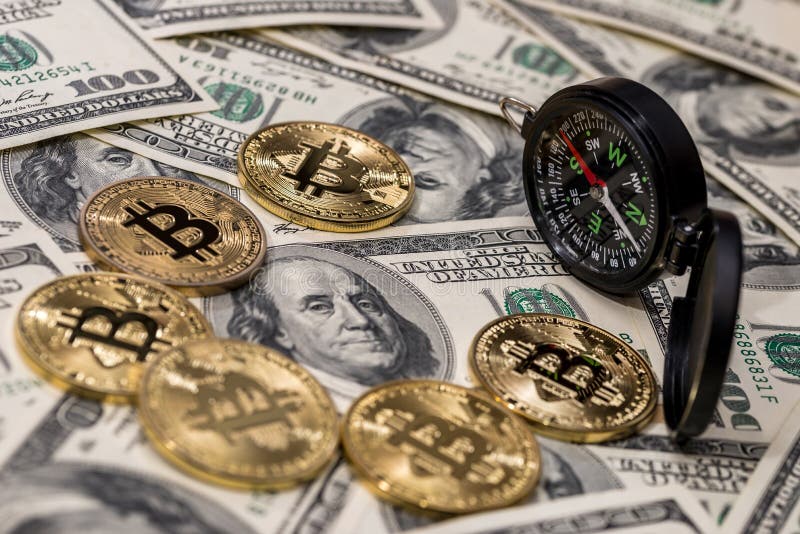 Bussola con bitcoin sopra le banconote in dollari immagini stock