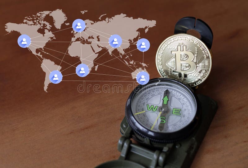 Bussola e bitcoin accanto alla mappa del mondo fotografia stock