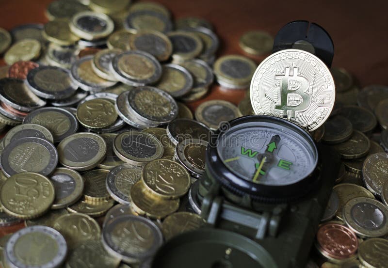 Bussola e bitcoin su una pila di monete in euro fotografia stock libera da diritti
