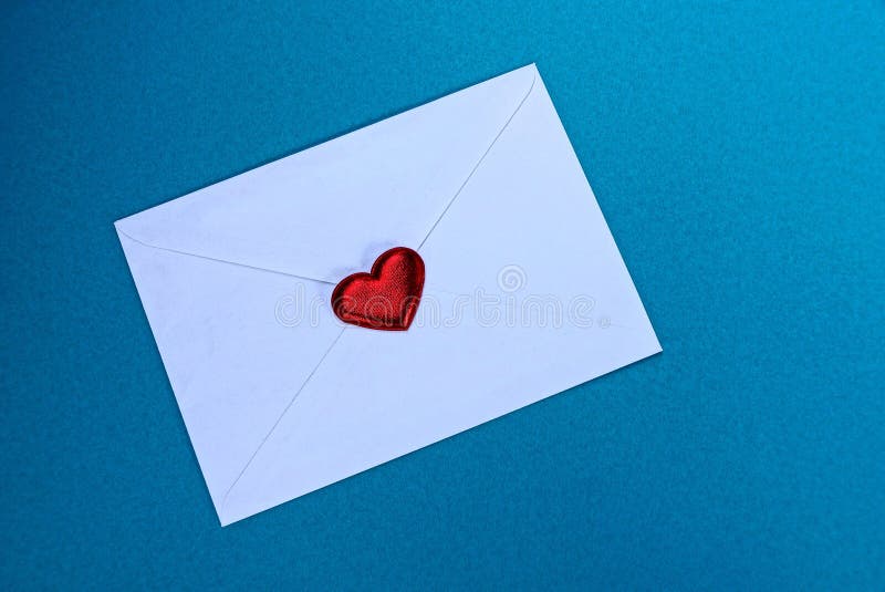 Busta chiusa bianca con un cuore rosso su un fondo blu immagine stock libera da diritti Busta chiusa bianca con un cuore rosso su un fondo blu immagine stock libera da diritti