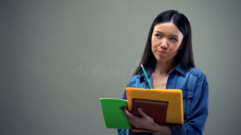 Busy asian woman writing down her plans and ideas, daily planning, to-do list royalty free stock photos Busy asian woman writing down her plans and ideas, daily planning, to-do list royalty free stock photos