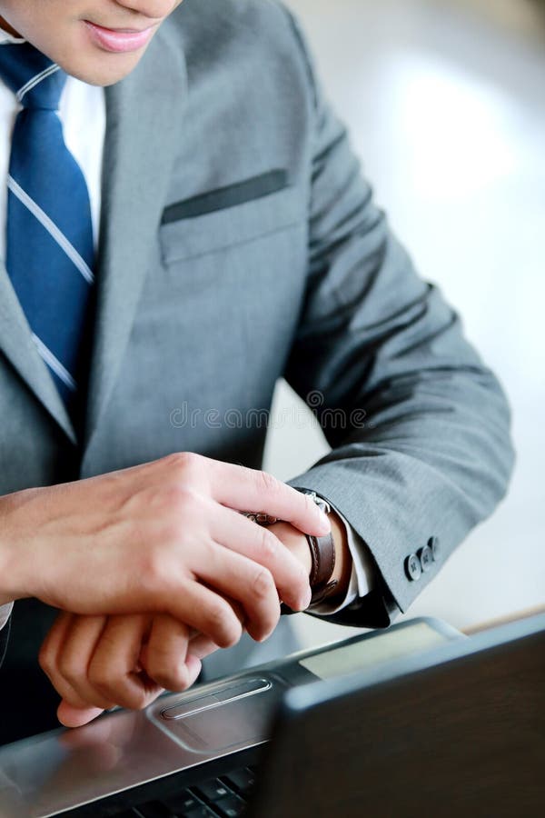 Busy businessman looking at his wristwatch while waiting