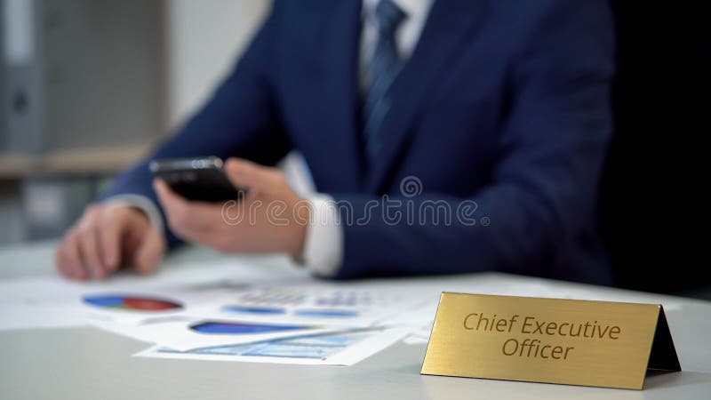 Busy chief executive officer using smartphone app, working on business report stock image Busy chief executive officer using smartphone app, working on business report stock image