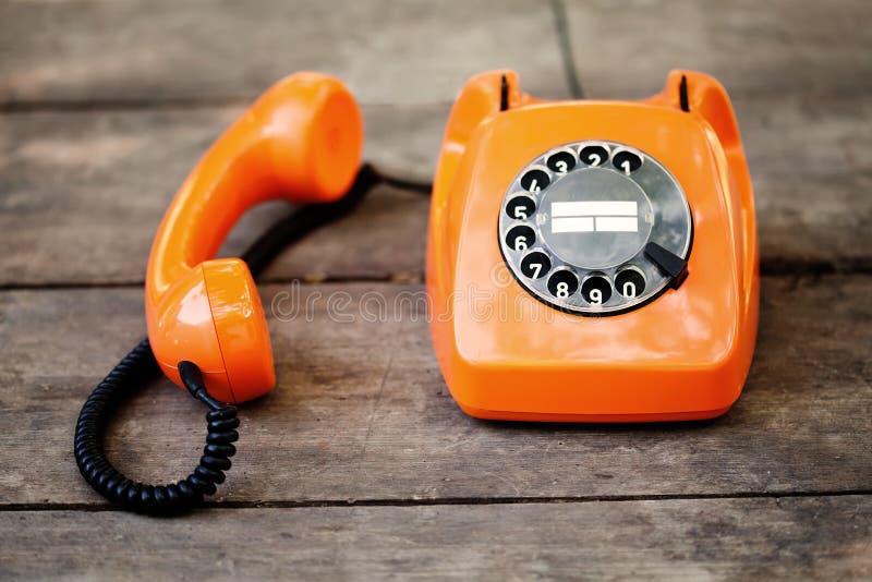 Busy retro phone orange color, handset receiver on wooden textured background. Shallow depth field photography royalty free stock images Busy retro phone orange color, handset receiver on wooden textured background. Shallow depth field photography royalty free stock images