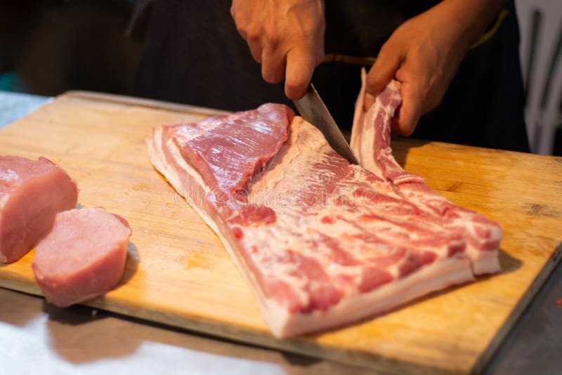 Butcher cut and slice organic fresh pork or beef meat by sharp knife