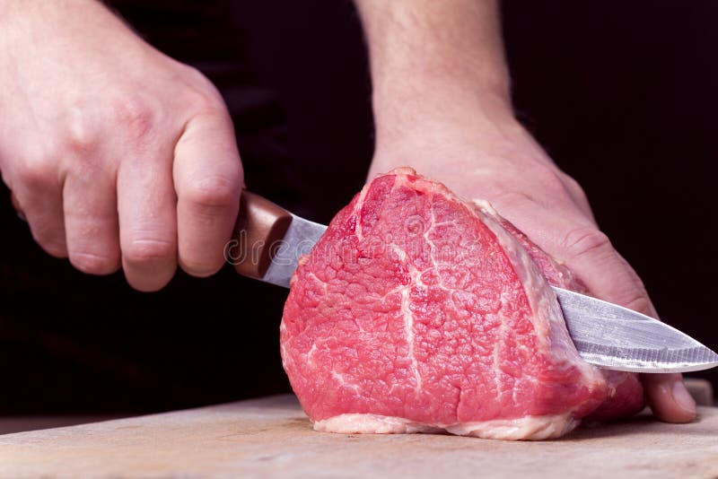 Butcher Cutting Beaf Meat on Kitchen. Food Background Stock Photo