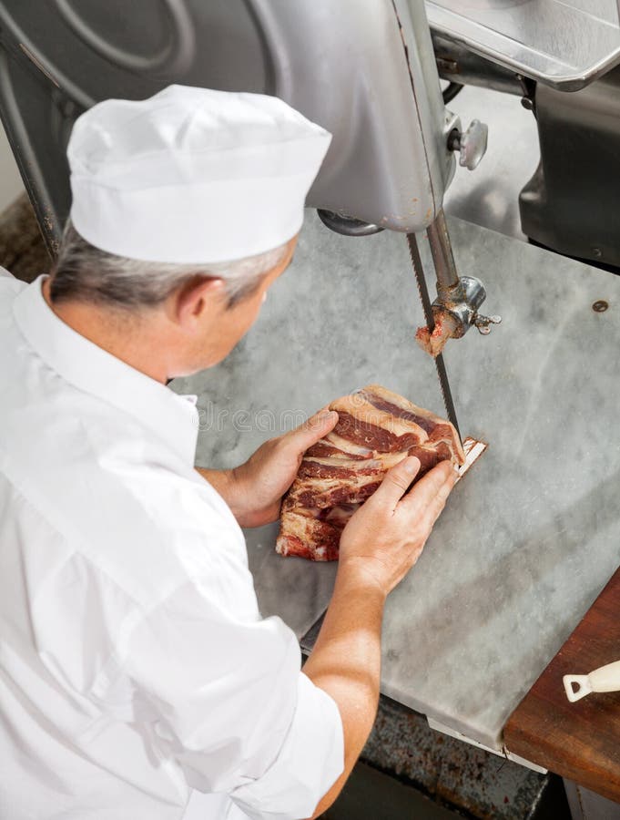 Butcher Cutting Fresh Meat With Bandsaw Stock Image - Image of mature