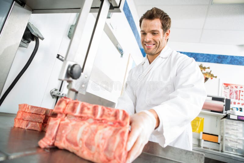 Butcher Cutting Meat On Bandsaw