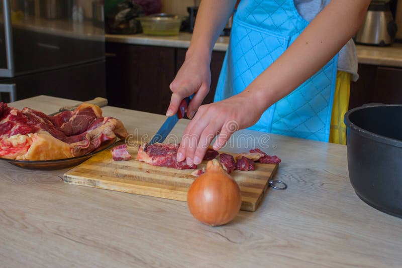 Butcher Cutting Meat on Kitchen. Man in the Kitchen Cutting a Piece of