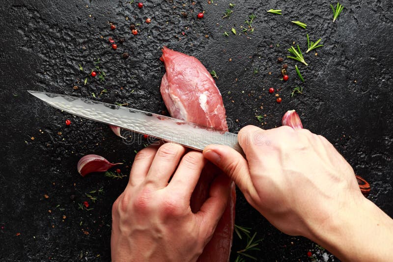 Butcher`s hands ready to cut with a knife raw pork tenderloin fillet royalty free stock photos Butcher`s hands ready to cut with a knife raw pork tenderloin fillet royalty free stock photos