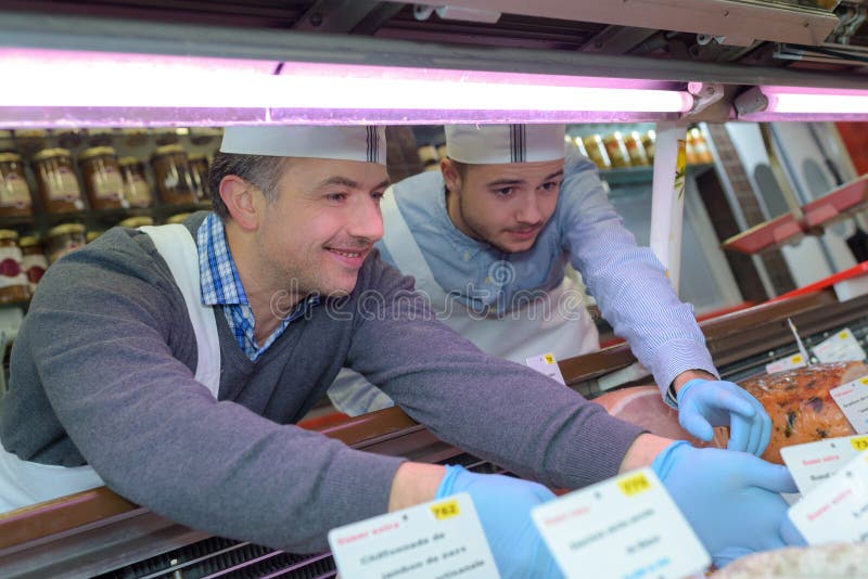 Butcher Teaching Apprentice How To Prepare Meat Stock Photo Image of