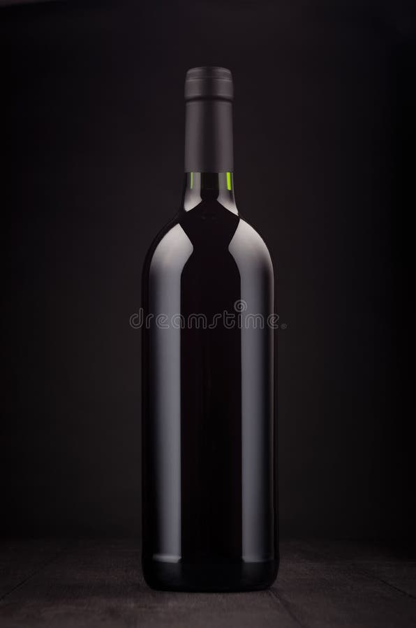 Bottle of red wine mock up on elegant dark black wooden background, vertical. Bottle of red wine mock up on elegant dark black wooden background, vertical