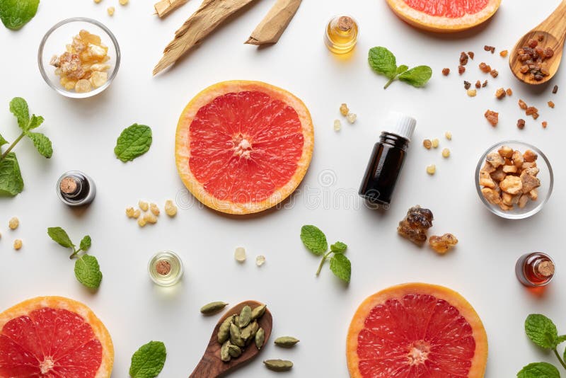 Butelki istotny olej z świeży grapefruitowym, miętowe, mira, biały sandałowiec, frankincense, kardamonowy zdjęcie royalty free Butelki istotny olej z świeży grapefruitowym, miętowe, mira, biały sandałowiec, frankincense, kardamonowy zdjęcie royalty free