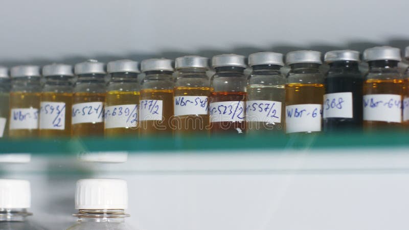 Butelki z produkt przerobu ropy naftowej próbkami na półce w lab