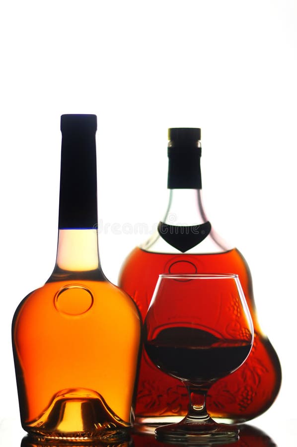 Bottles and a cognac glass isolated on white. Bottles and a cognac glass isolated on white