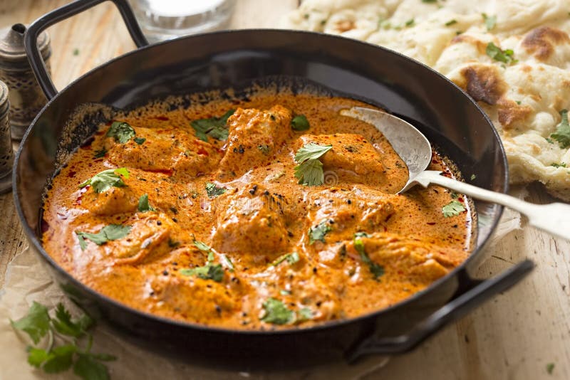 Butter chicken. Curry with coriander and naan bread royalty free stock image