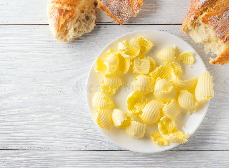 Butter and fresh crunchy homemade bread. Healthy organic breakfast on rustic white wooden table royalty free stock photo Butter and fresh crunchy homemade bread. Healthy organic breakfast on rustic white wooden table royalty free stock photo